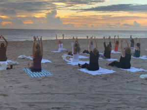 View of yoga class with their hands up in the air