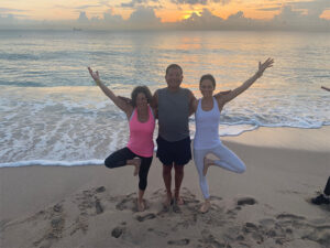 Two women and a man doing a yoga pose together