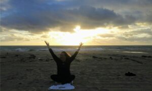 woman stretching her arms up to the sky