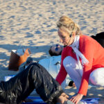 View of yoga instructor adjusting student