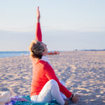 View of yoga instructor stretching her hand up