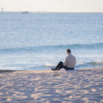 View of man sitting by the shore