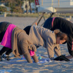 View of three people doing yoga