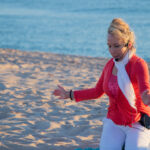 Front view of woman teaching yoga on the beach